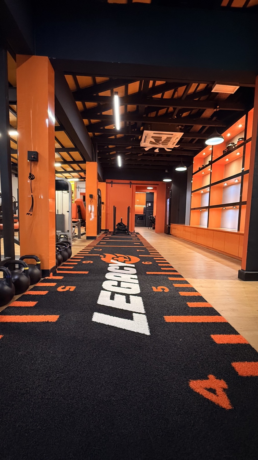 Turf lane at LEGACY+ with branded runway and kettlebells.