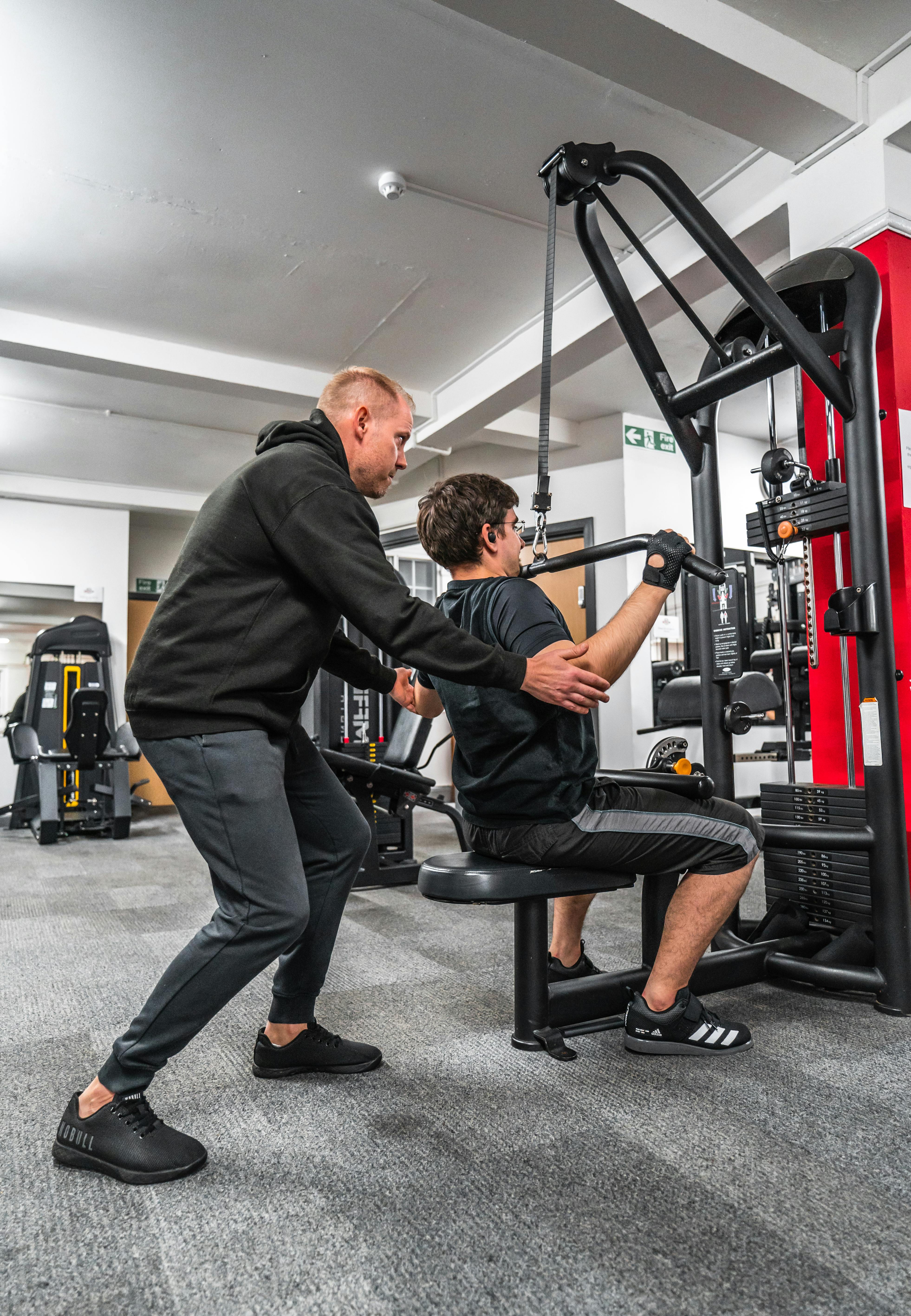 Private coach guiding a client through a strength training session.