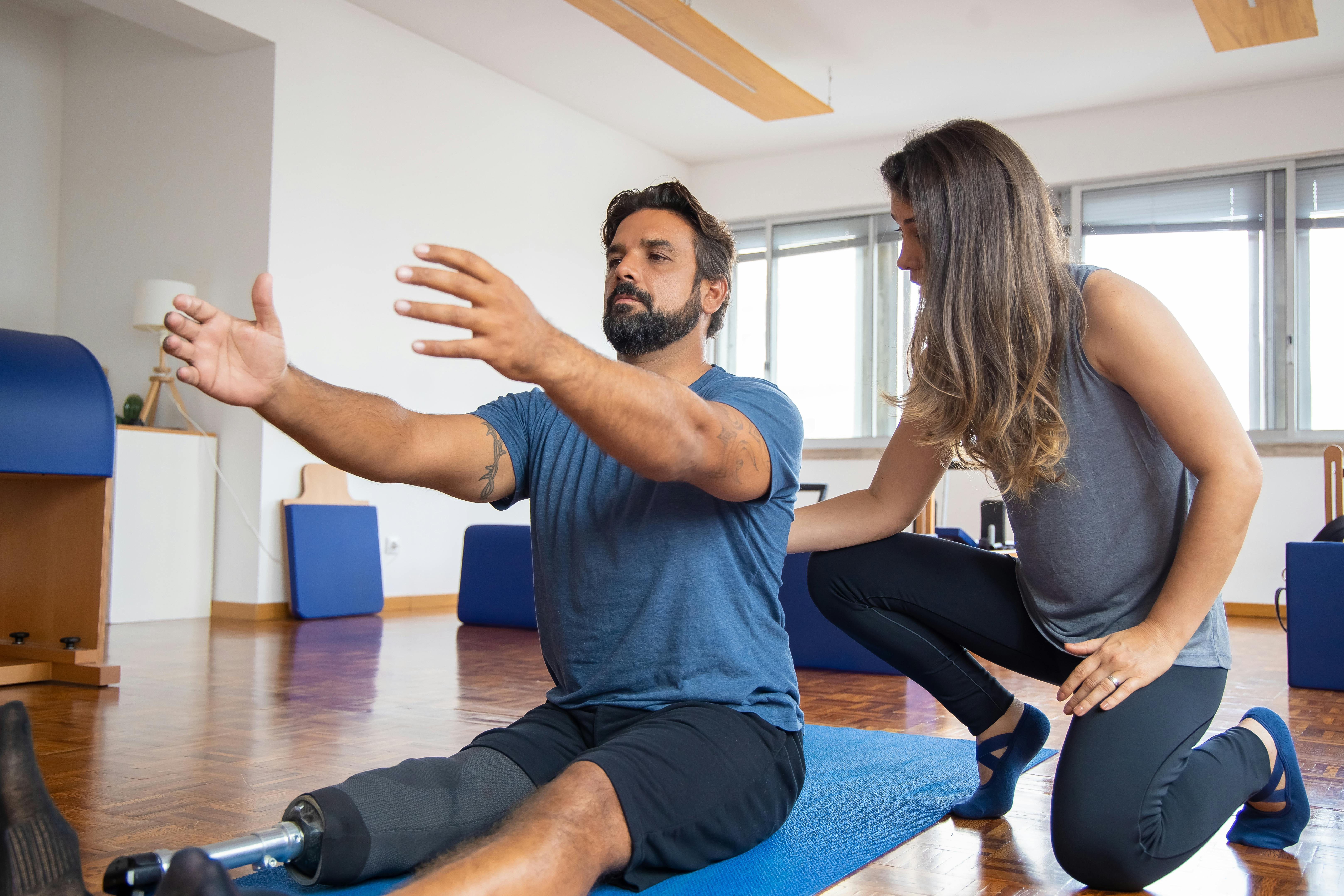 Coach guiding a client through controlled rehab-focused strength training.